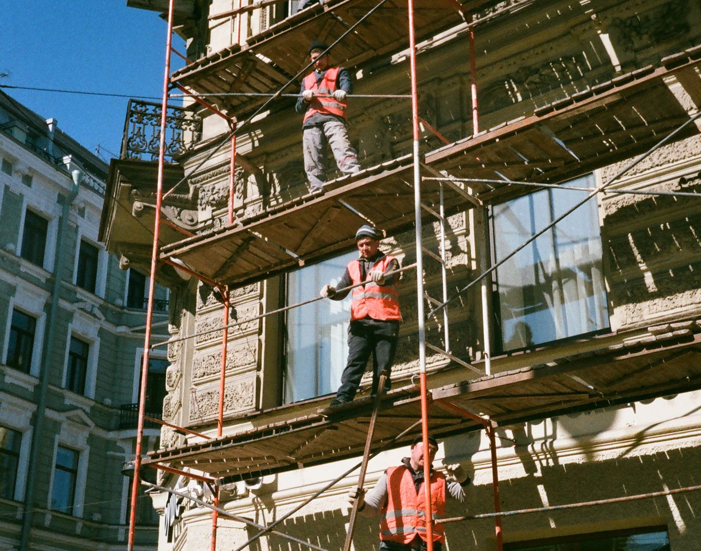 Maler bei Fassaden- und Stuckarbeiten auf dem Gerüst an einem Altbau